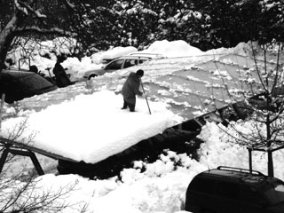 Hausmeister Reinhold befreit die Autostellplätze von den Schneemassen